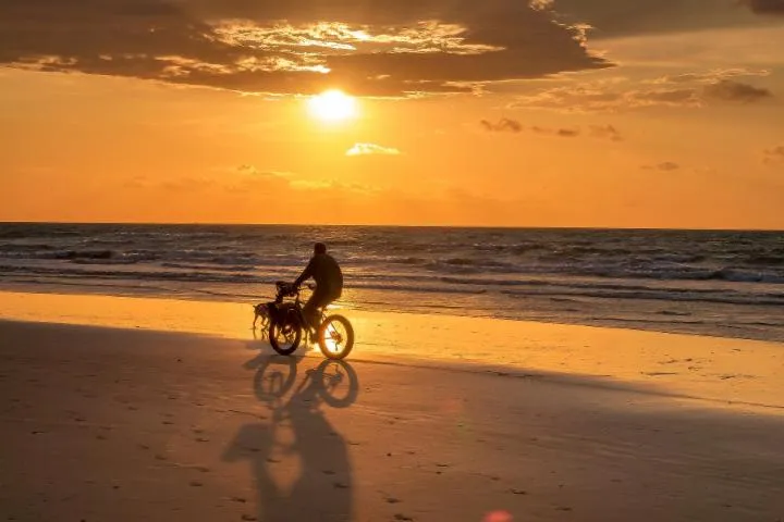 Image qui illustre: Balade à vélo sur la plage au coucher de soleil